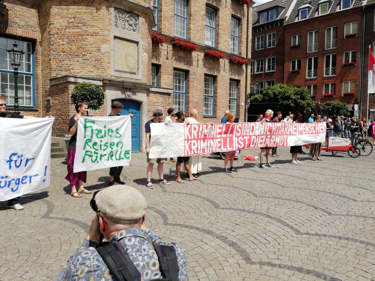 Fifty Fifty-Aktivisten demonstrieren mit Bannern wie "Freie Fahrt für arme Bürger", "Freies Reisen für alle", "Kriminell sind nicht arme Menschen, Kriminell ist die Armut." vor dem Rathaus in Düsseldorf. 