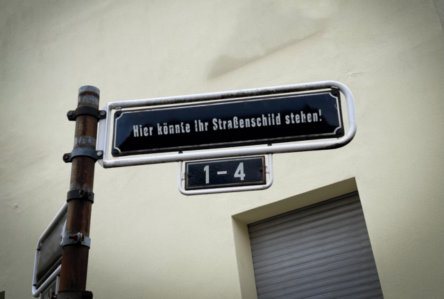 Zu sehen ist ein Straßenschild in Düsseldorf mit der Aufschrift "Hier könnte Ihr Straßenschild stehen!"